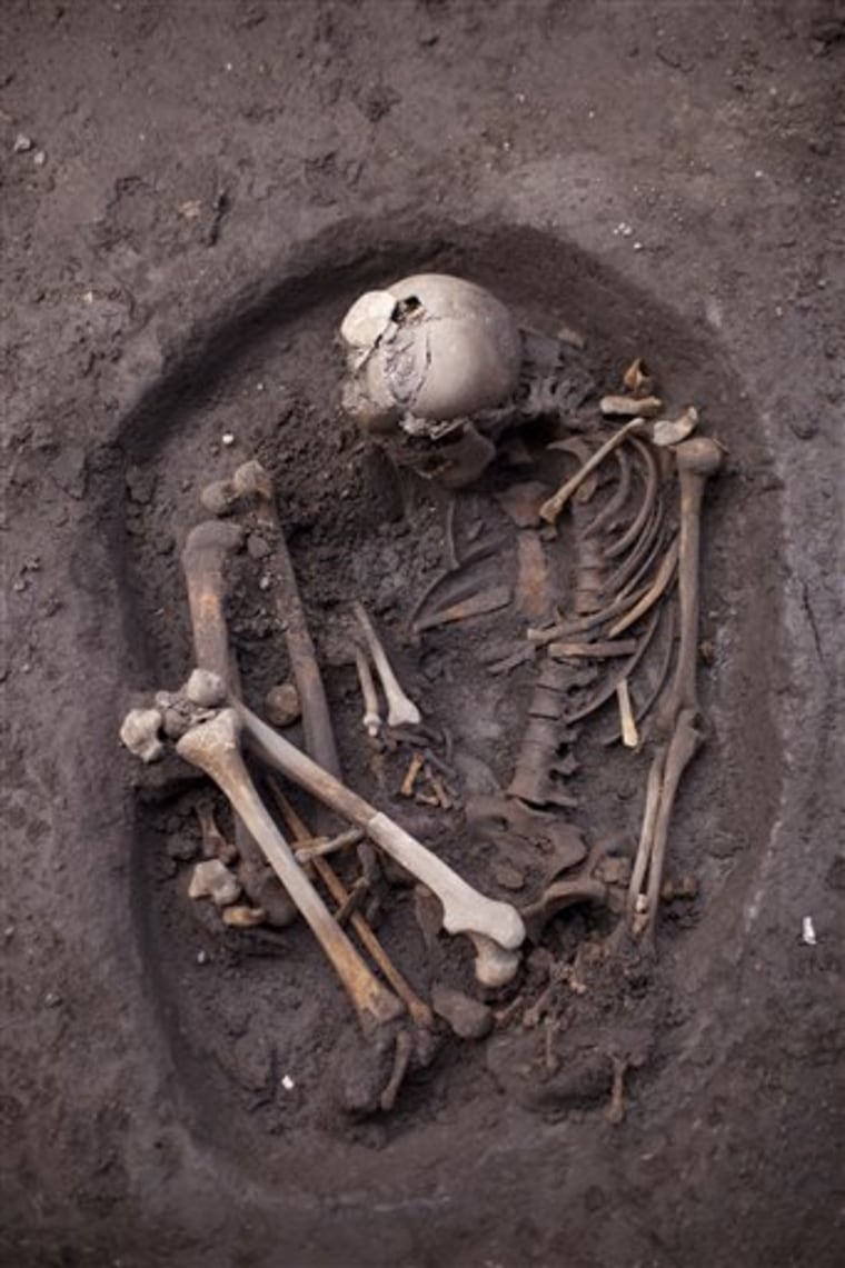 An unearthed skeleton dating back about 700 years is seen at a recently discovered archeological site in Mexico City, Friday, July 13, 2012. According to Mexico's National Institute of Anthropology and History, INAH, the site is about 700 years old and is a neighborhood of Tepaneca merchants. (AP Photo/Alexandre Meneghini)
